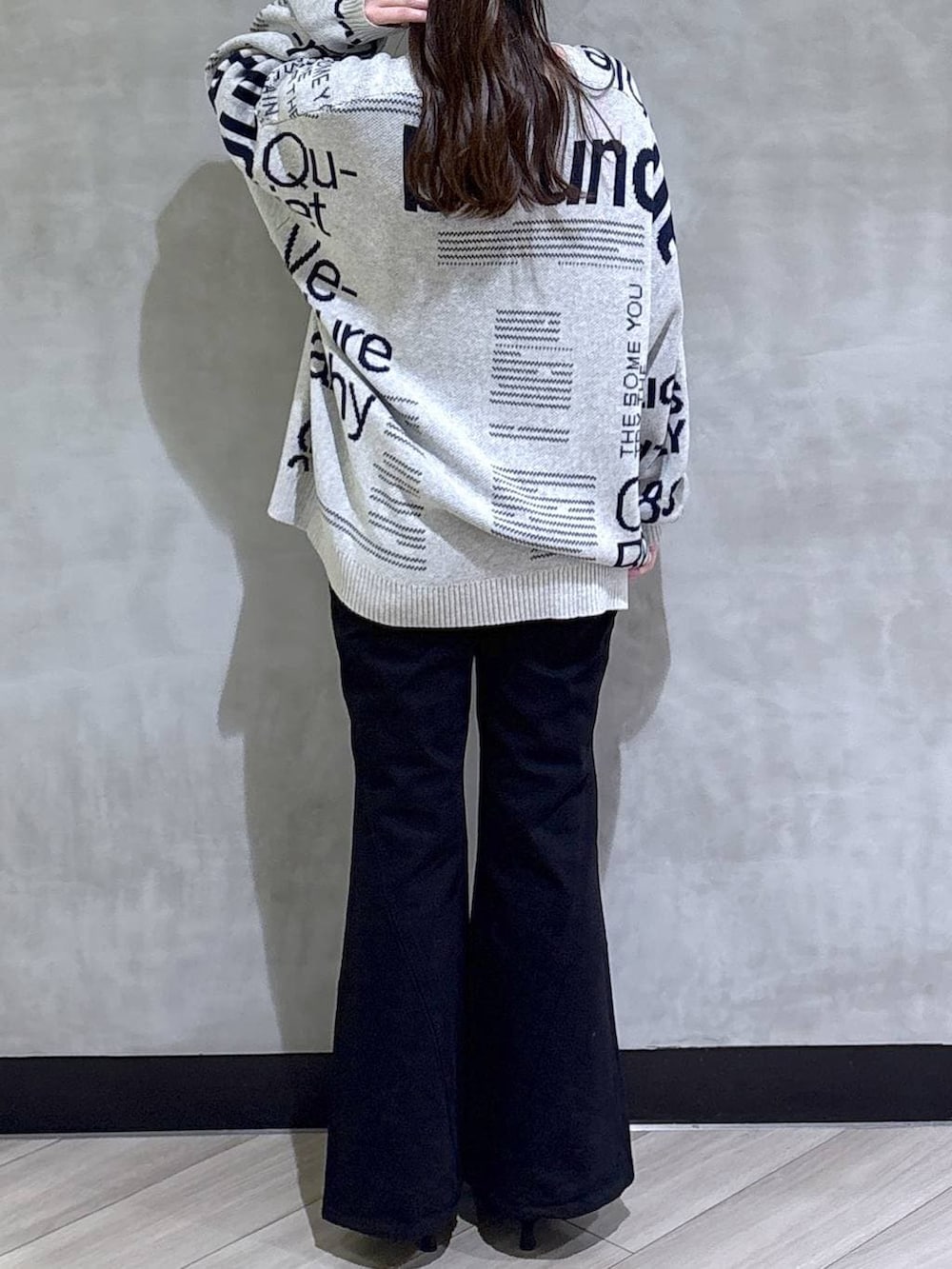 ブルー系のデニムパンツ、ブラック系のサンダル、グレー系のニット/セーターを着用したレディースの冬コーディネートの6枚目の写真