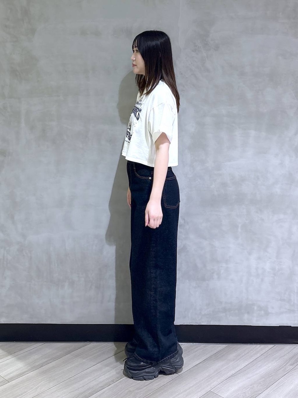 ブラック系のスニーカー、ブルー系のデニムパンツ、ホワイト系のTシャツ/カットソーを着用したレディースの夏コーディネートの3枚目の写真