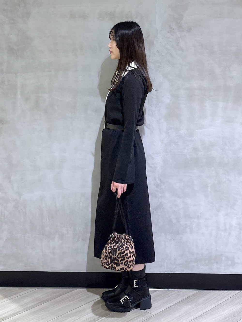 ブラック系のブーツ、ブラック系のワンピース、ブラック系のベルトを着用したレディースの秋コーディネートの3枚目の写真