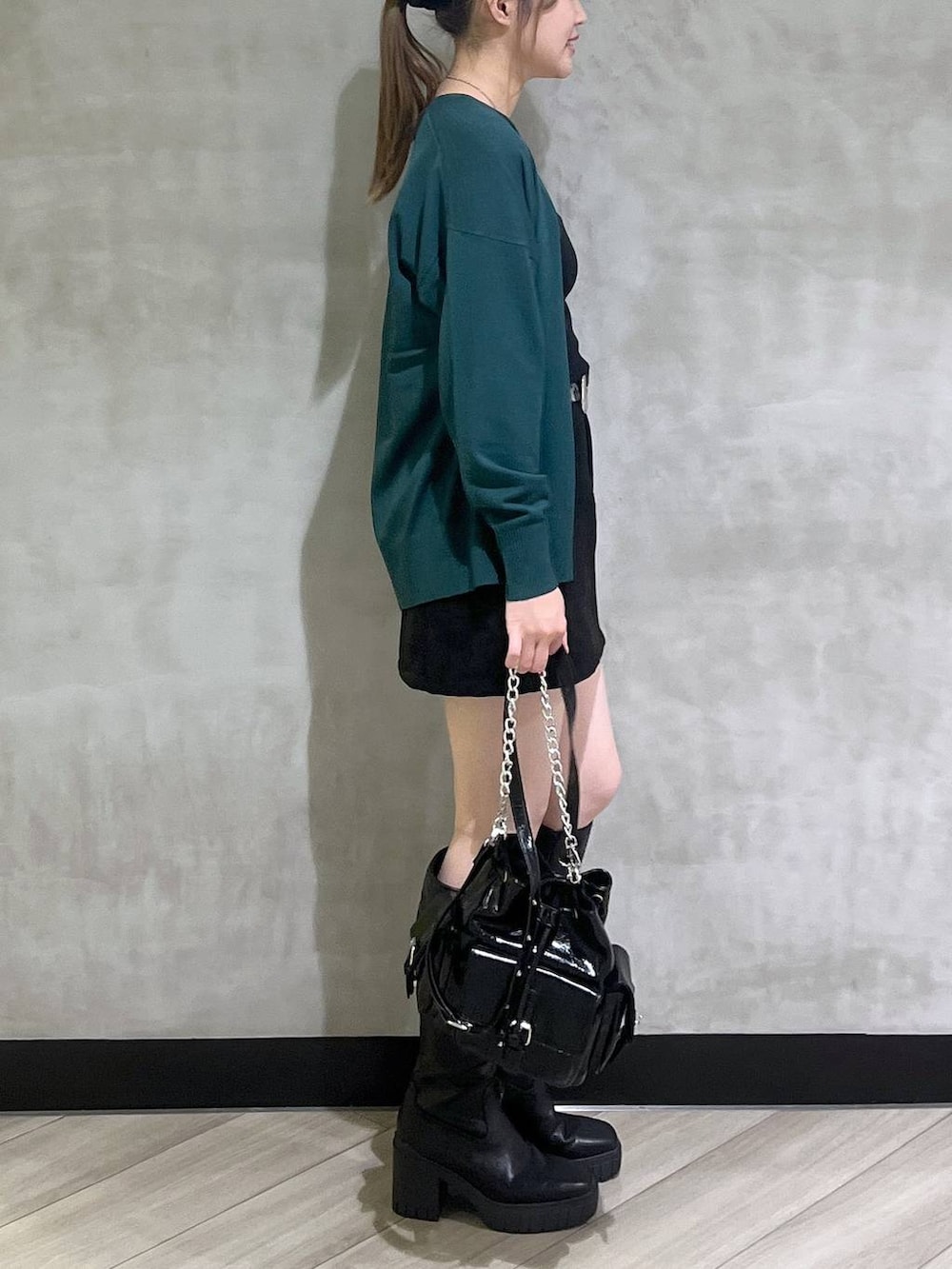 ブラック系のブーツ、ブラック系のスカート、グリーン系のカーディガン/ボレロを着用したレディースの秋コーディネートの7枚目の写真
