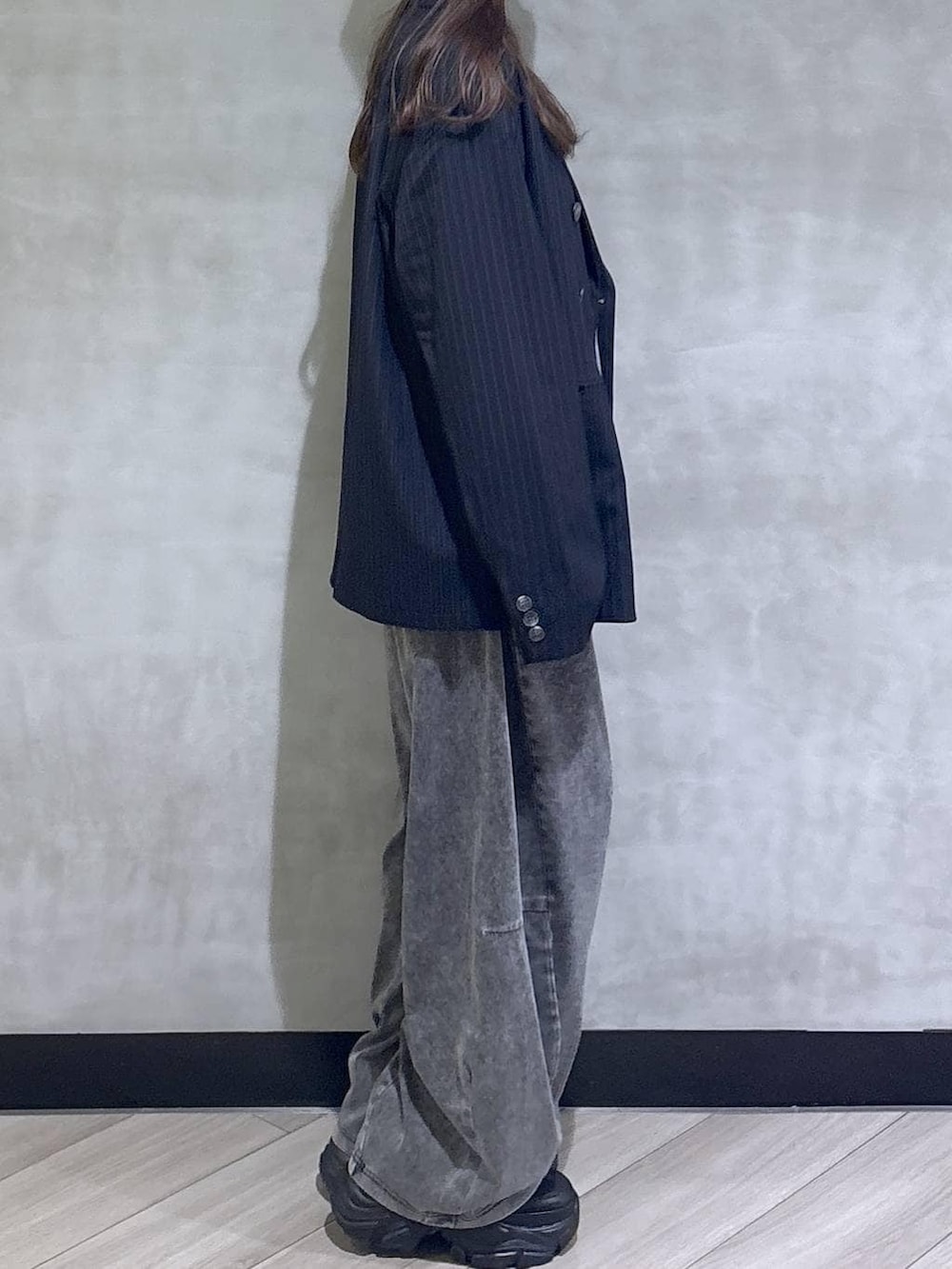 ブラック系のスニーカー、ブラック系のデニムパンツ、ブルー系のテーラードジャケットを着用したレディースの春コーディネートの7枚目の写真