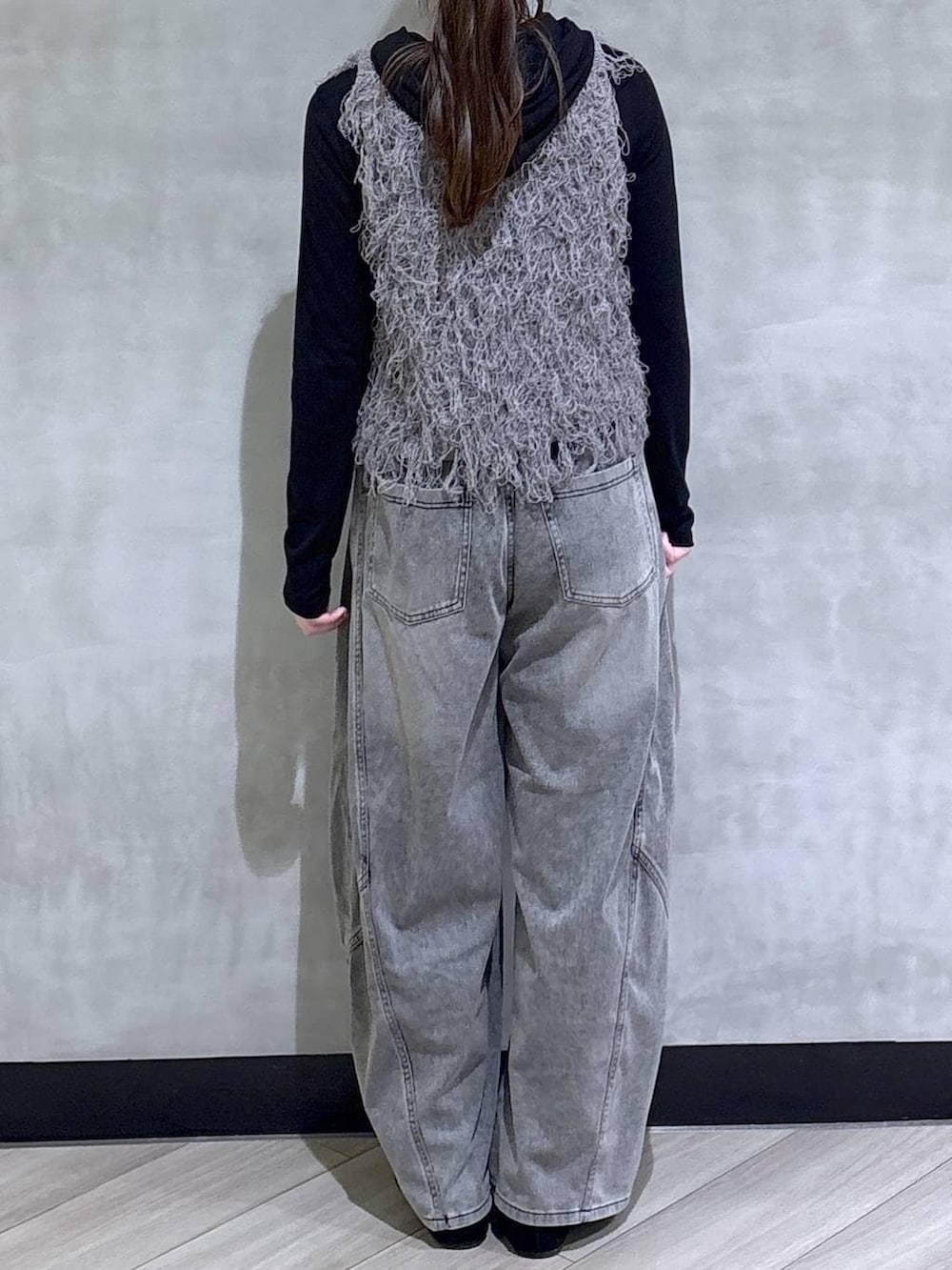 グレー系のベスト、ブラック系のデニムパンツ、ブラック系のTシャツ/カットソーを着用したレディースの春コーディネートの6枚目の写真