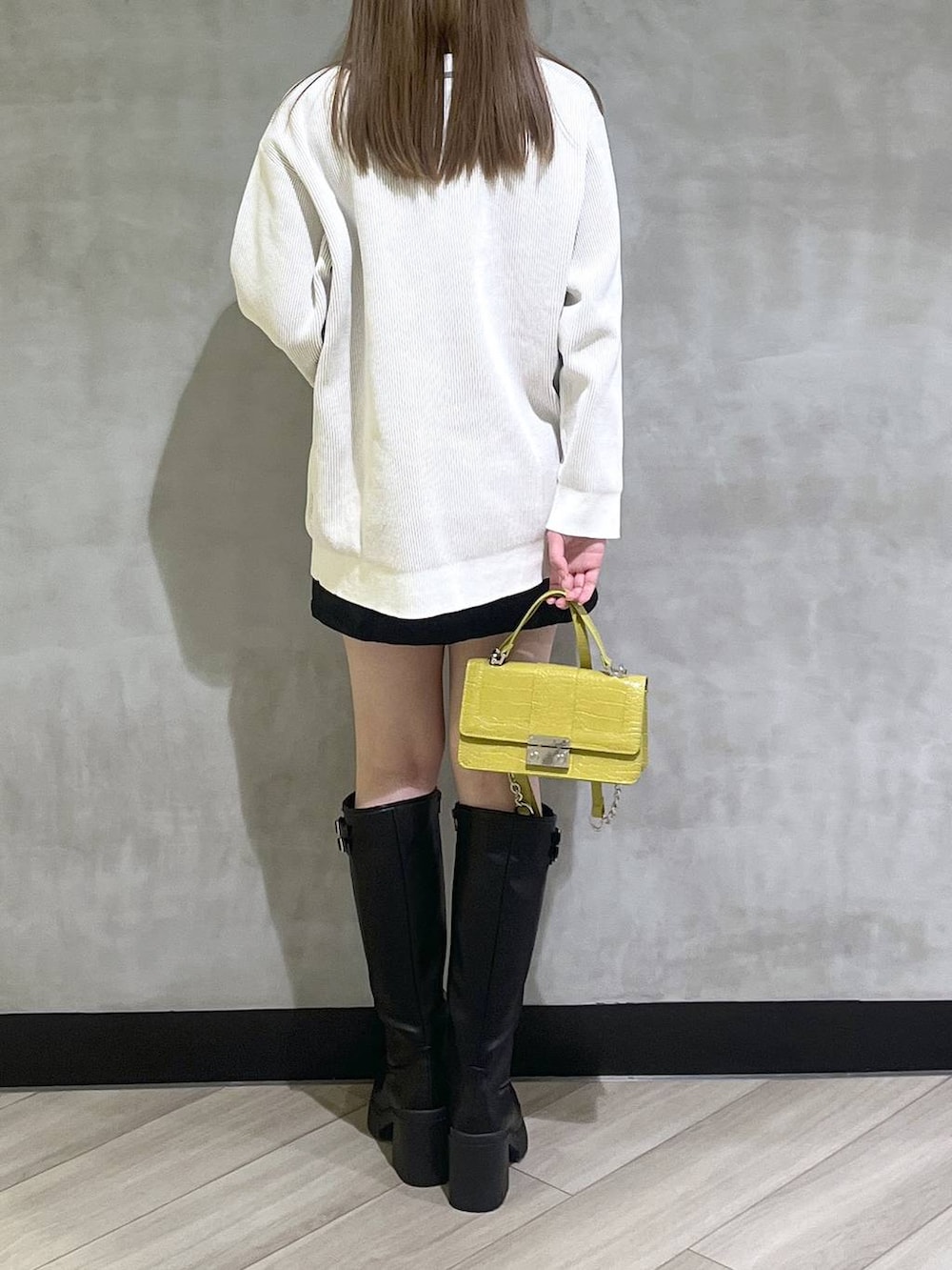 ブラック系のブーツ、ブラック系のスカート、ホワイト系のカーディガン/ボレロを着用したレディースの秋コーディネートの6枚目の写真