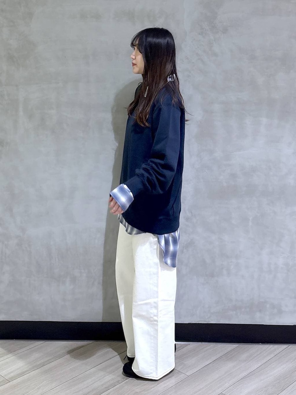 ブルー系のスウェット、ブルー系のスラックス、ブラック系のモカシン/デッキシューズを着用したレディースの春コーディネートの3枚目の写真