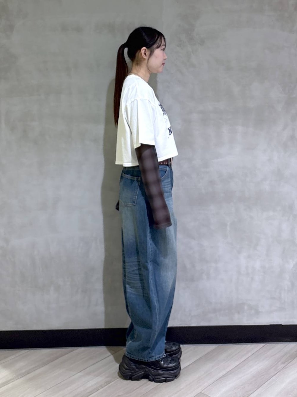 ブラック系のスニーカー、ホワイト系のTシャツ/カットソー、ブルー系のデニムパンツを着用したレディースの春コーディネートの7枚目の写真