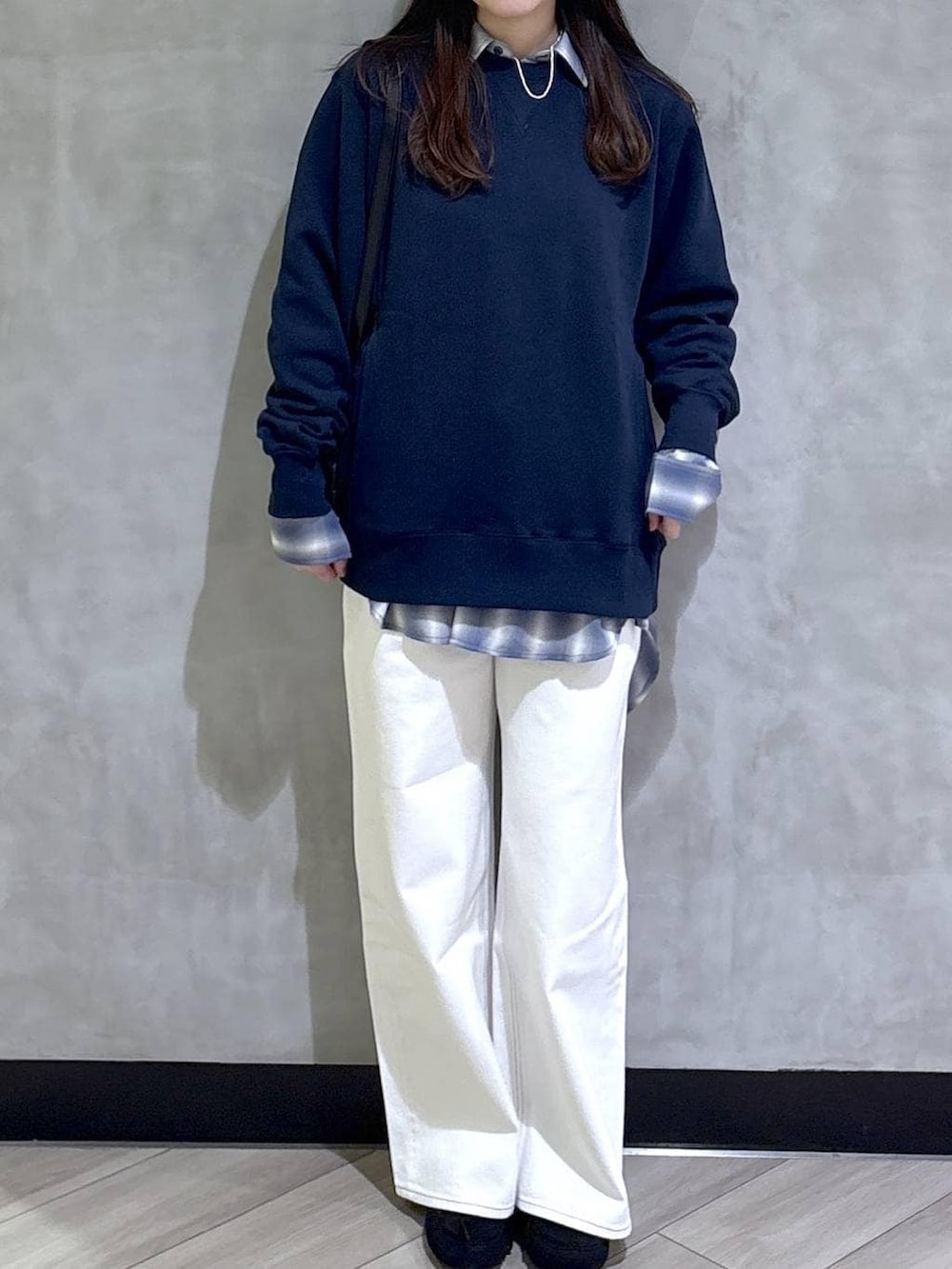 ブルー系のスウェット、ブルー系のスラックス、ブラック系のモカシン/デッキシューズを着用したレディースの春コーディネートの2枚目の写真