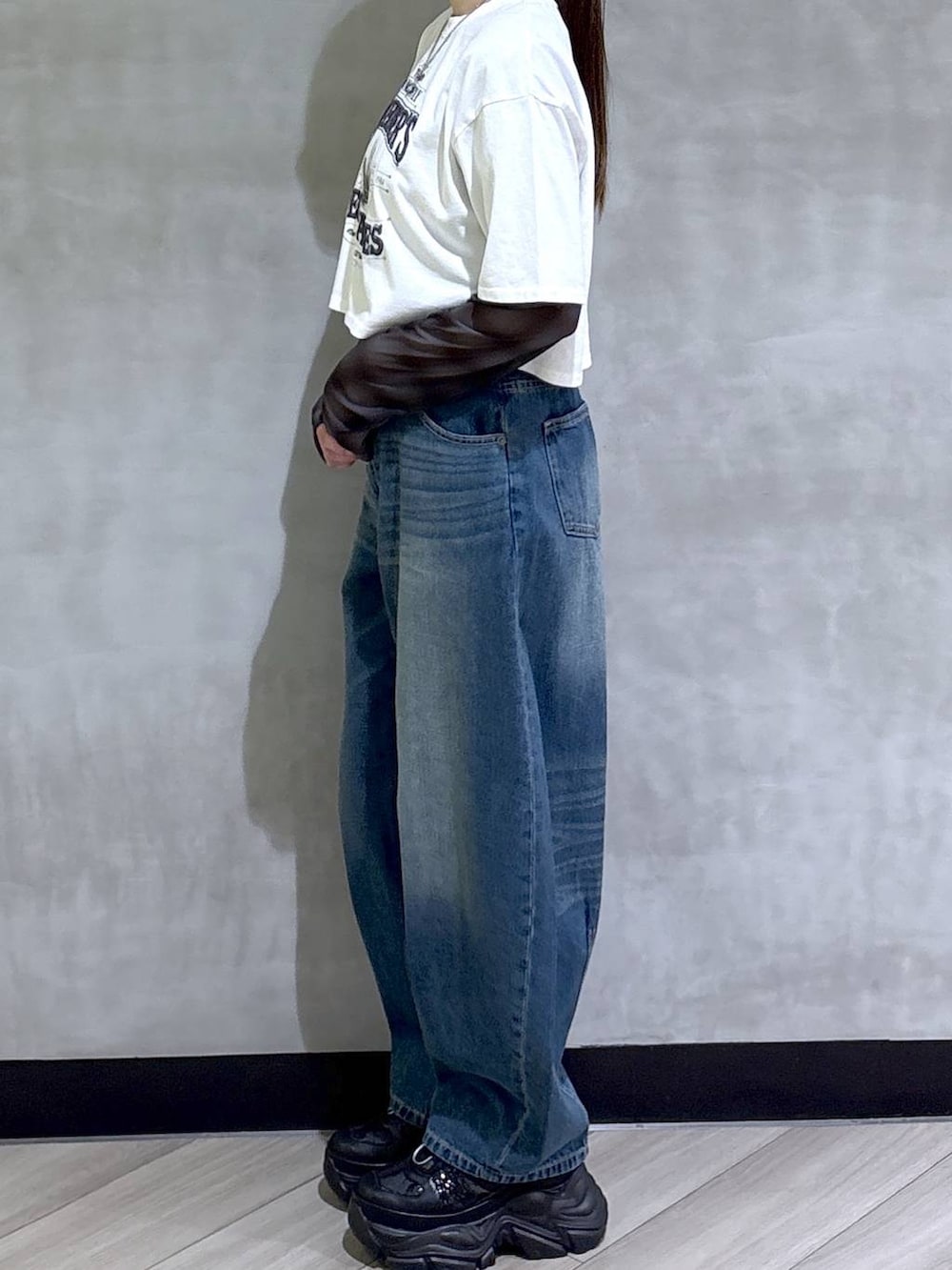 ブラック系のスニーカー、ホワイト系のTシャツ/カットソー、ブルー系のデニムパンツを着用したレディースの春コーディネートの4枚目の写真