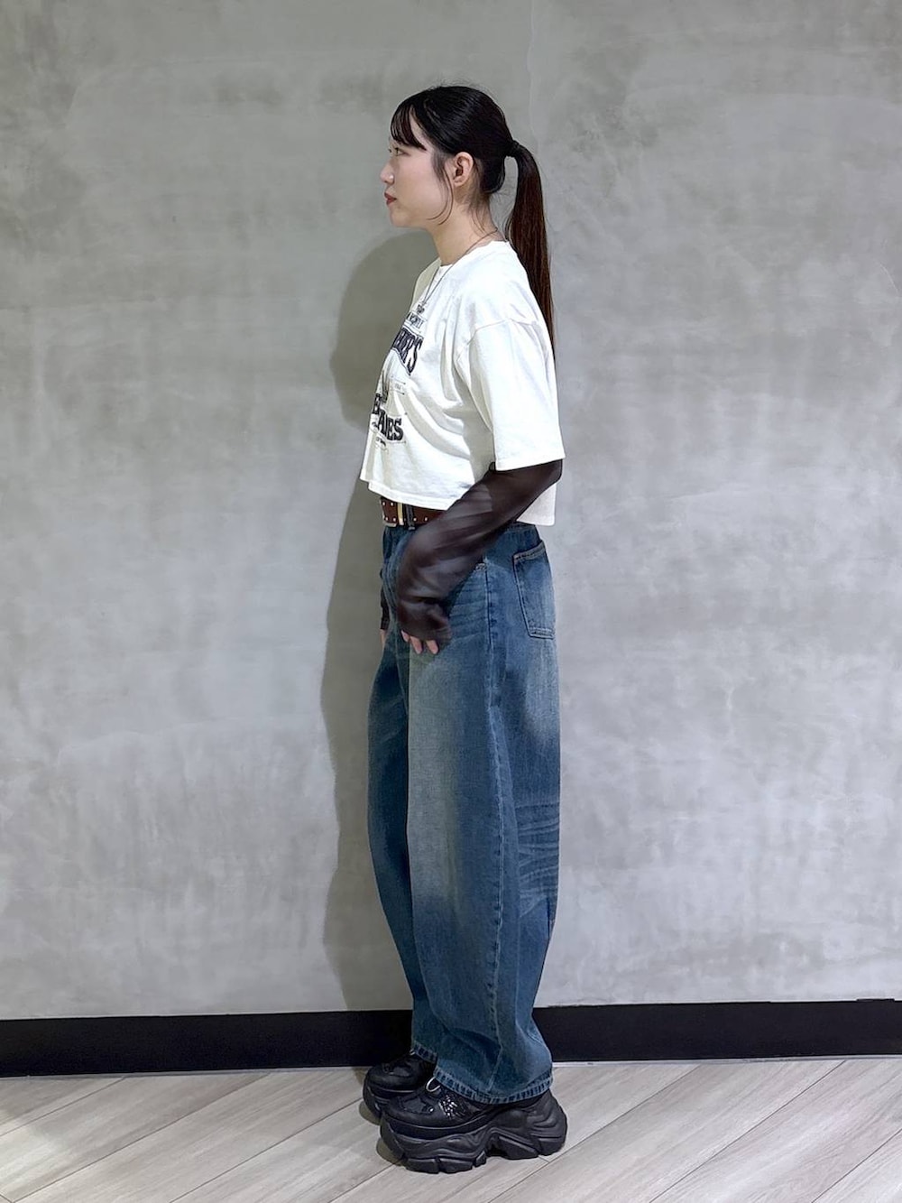 ブラック系のスニーカー、ホワイト系のTシャツ/カットソー、ブルー系のデニムパンツを着用したレディースの春コーディネートの3枚目の写真