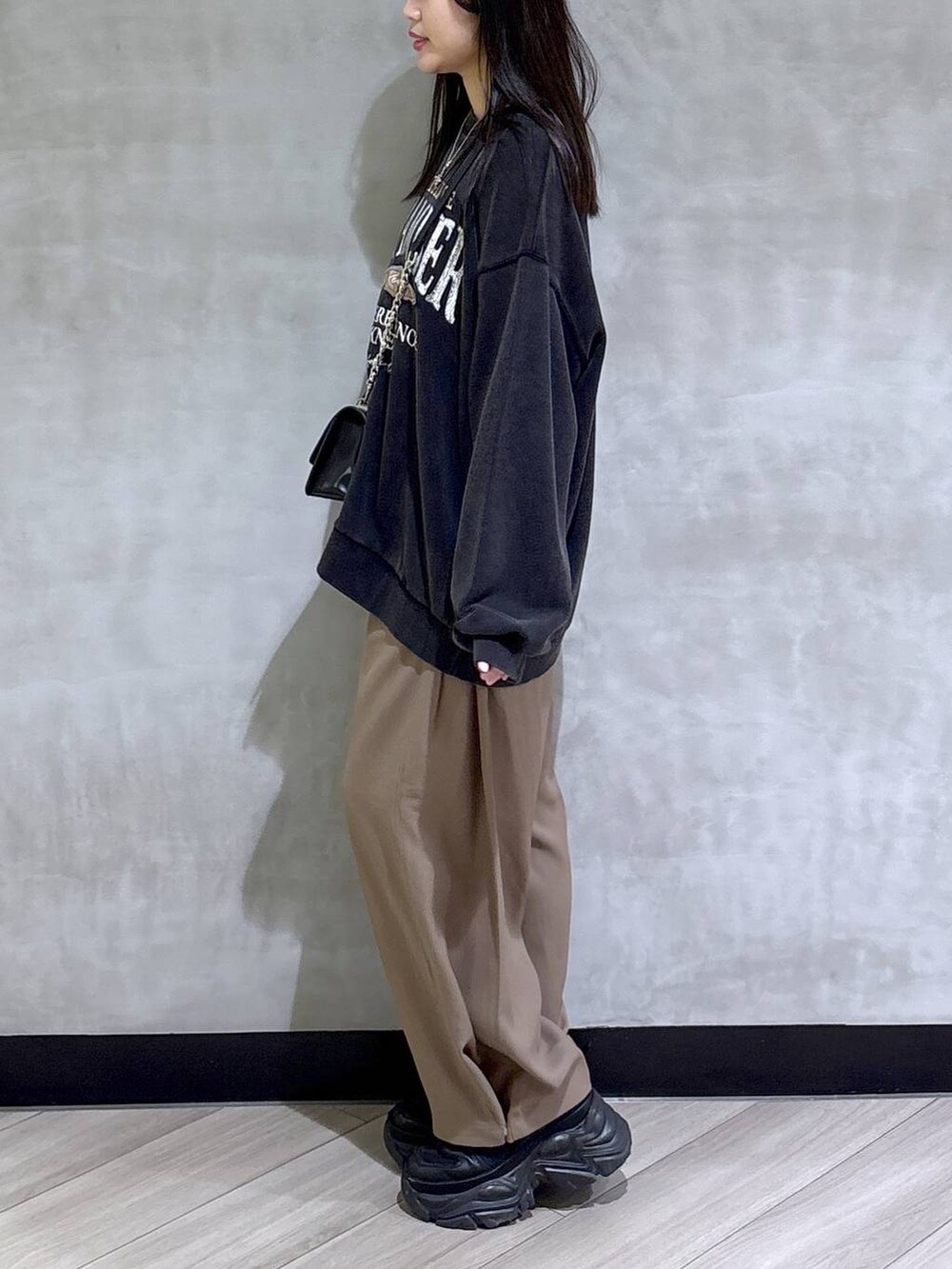 ブラック系のブーツ、グレー系のスウェット、ベージュ系のスラックスを着用したレディースの秋コーディネートの4枚目の写真