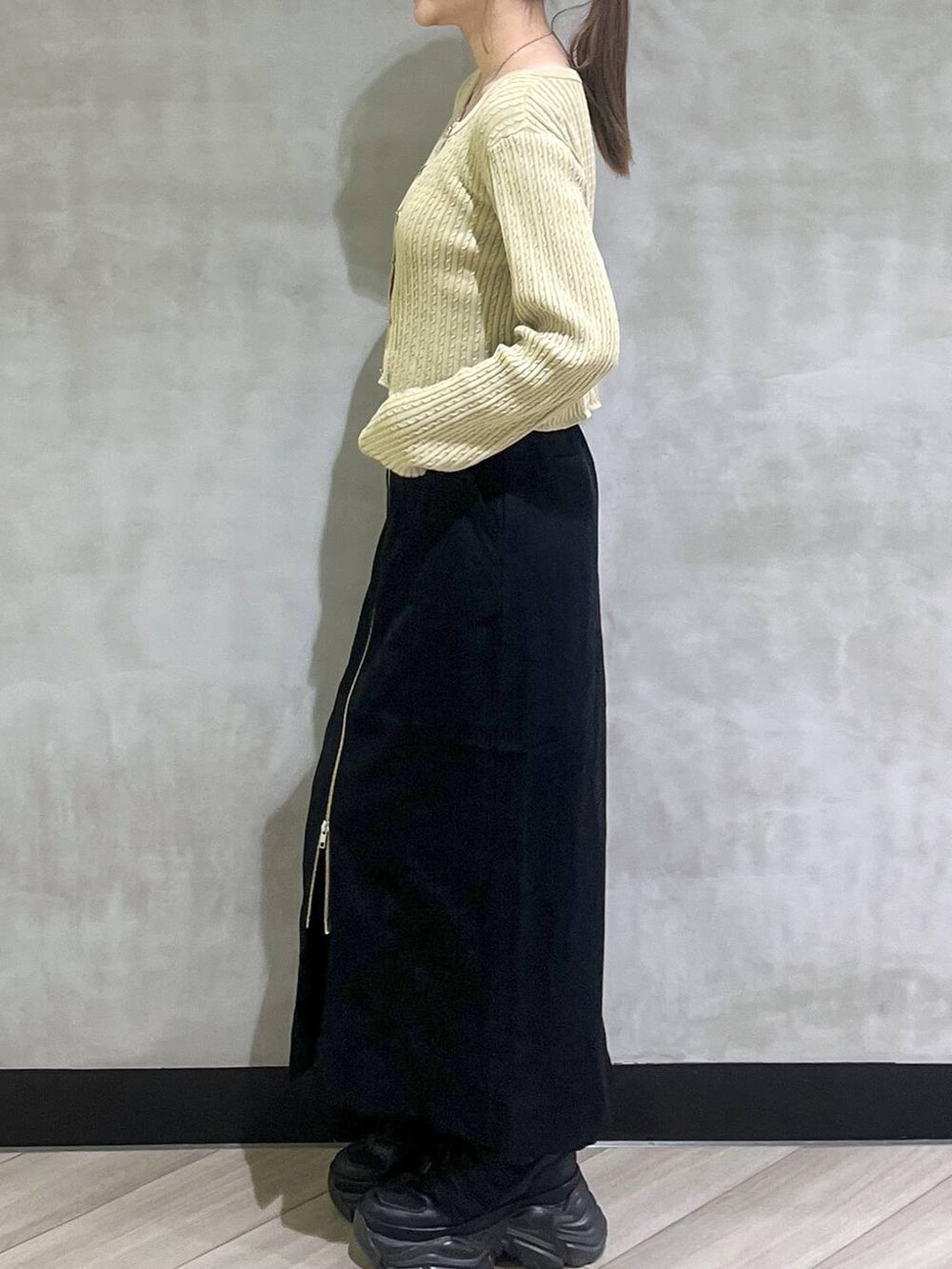 ブラック系のブーツ、イエロー系のカーディガン/ボレロ、ブラック系のスカートを着用したレディースの秋コーディネートの4枚目の写真