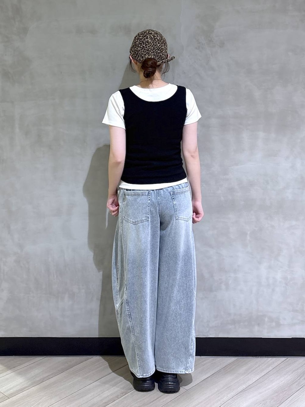 ブルー系のデニムパンツ、ブラック系のサンダル、ブラック系のタンクトップを着用したレディースの春コーディネートの5枚目の写真