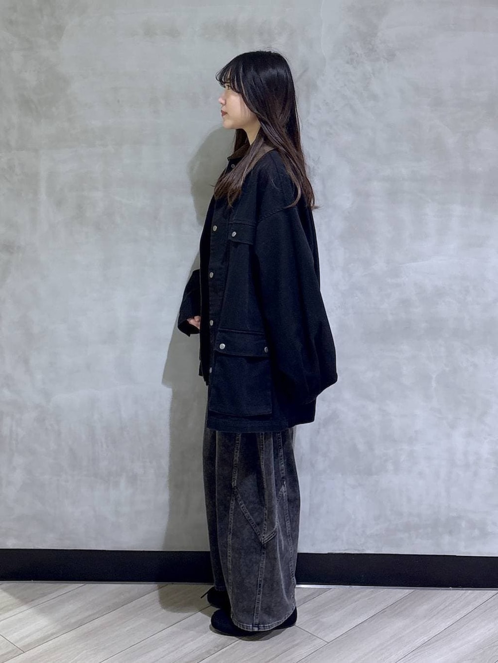 ブラック系のデニムパンツ、ブラック系のモカシン/デッキシューズ、ブラック系のその他アウターを着用したレディースの春コーディネートの3枚目の写真