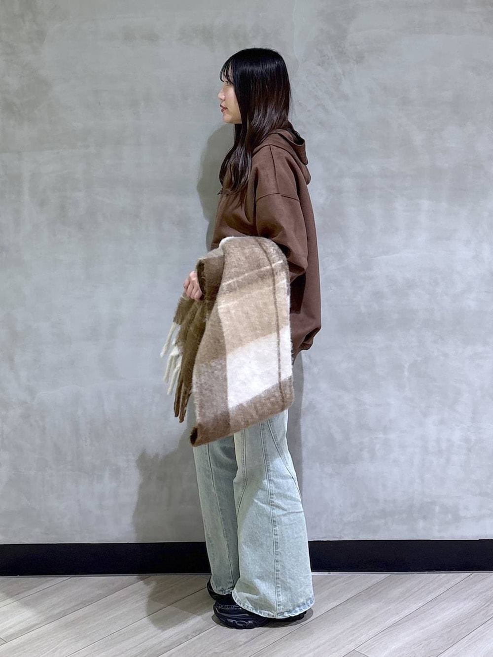 ブルー系のデニムパンツ、ブラック系のパーカー、ブラック系のローファーを着用したレディースの冬コーディネートの3枚目の写真