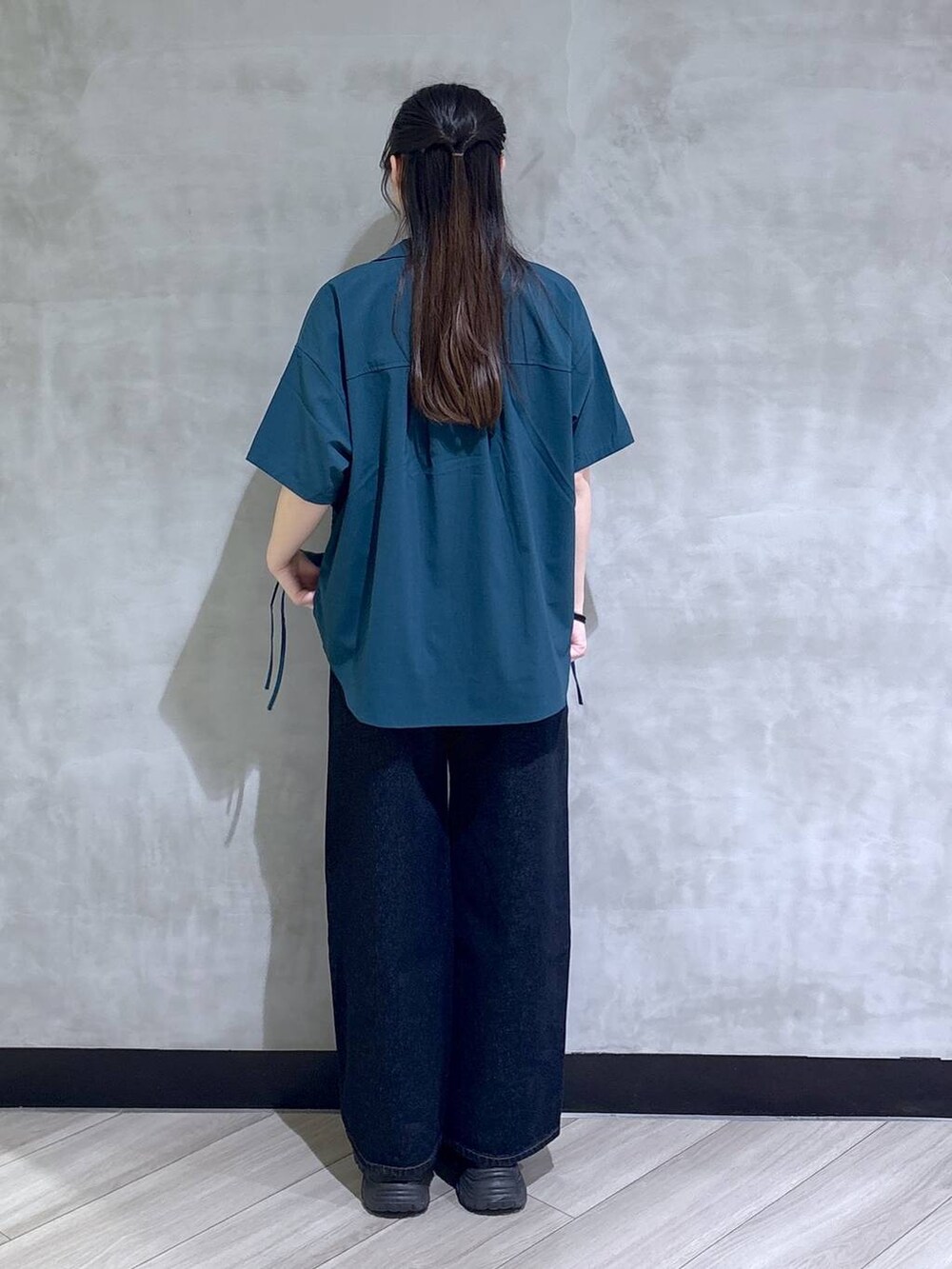 ブルー系のデニムパンツ、ブラック系のサンダル、グリーン系のシャツ/ブラウスを着用したレディースの春コーディネートの5枚目の写真