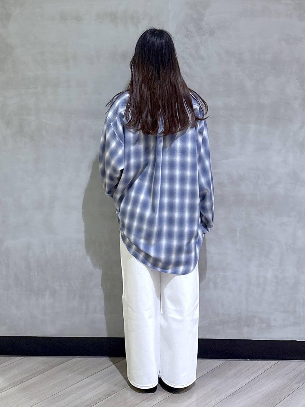 ホワイト系のデニムパンツ、ブラック系のモカシン/デッキシューズ、ブルー系のシャツ/ブラウスを着用したレディースの春コーディネートの5枚目の写真
