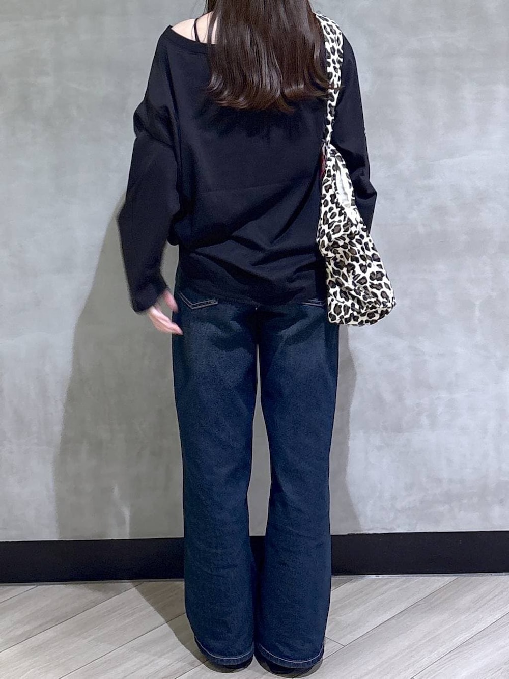 ブルー系のスラックス、ブラック系のモカシン/デッキシューズ、ブラック系のTシャツ/カットソーを着用したレディースの冬コーディネートの5枚目の写真