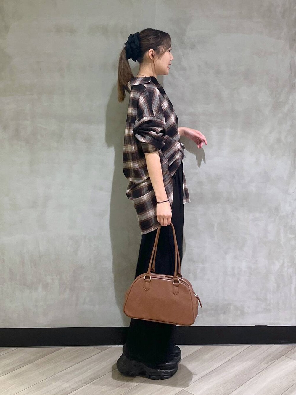 ブラック系のスニーカー、ブラック系のスラックス、ブラウン系のシャツ/ブラウスを着用したレディースの秋コーディネートの8枚目の写真