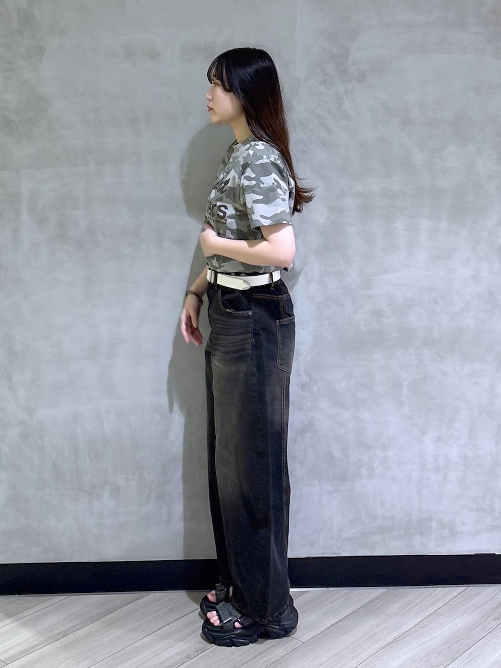 ブラック系のデニムパンツ、グレー系のサンダル、その他のTシャツ/カットソーを着用したレディースの春コーディネートの3枚目の写真
