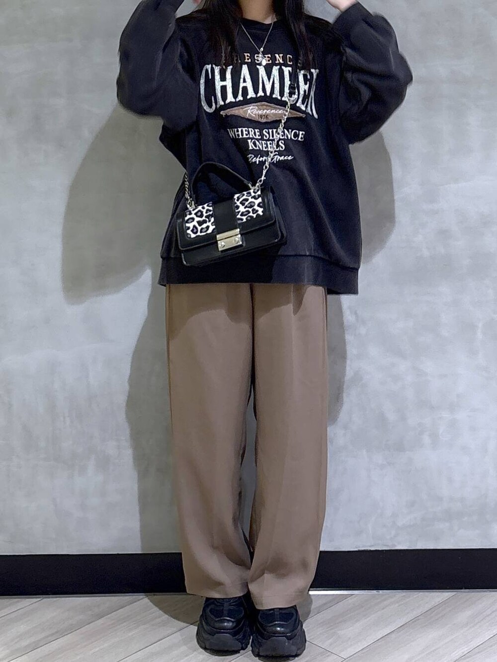 ブラック系のブーツ、グレー系のスウェット、ベージュ系のスラックスを着用したレディースの秋コーディネートの2枚目の写真