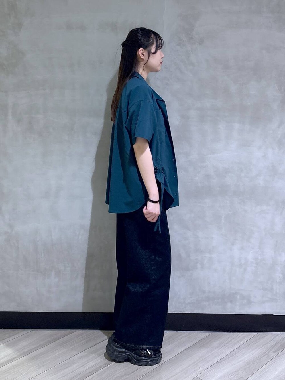 ブルー系のデニムパンツ、ブラック系のサンダル、グリーン系のシャツ/ブラウスを着用したレディースの春コーディネートの6枚目の写真