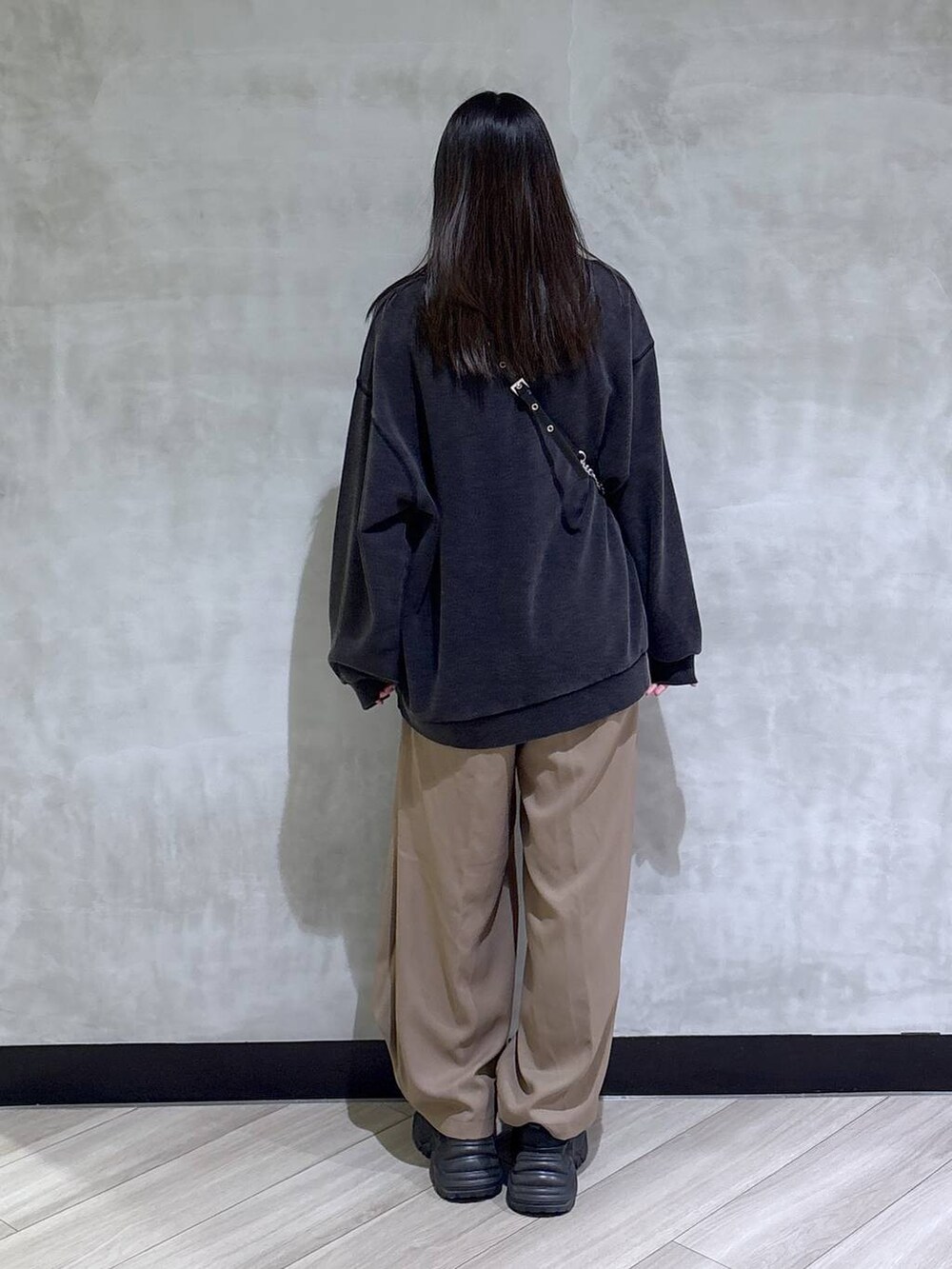 ブラック系のブーツ、グレー系のスウェット、ベージュ系のスラックスを着用したレディースの秋コーディネートの5枚目の写真