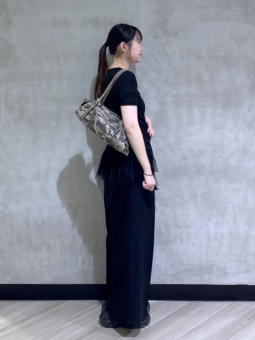 グレー系のサンダル、ブラック系のスラックス、ブラック系のTシャツ/カットソーを着用したレディースの春コーディネートの6枚目の写真