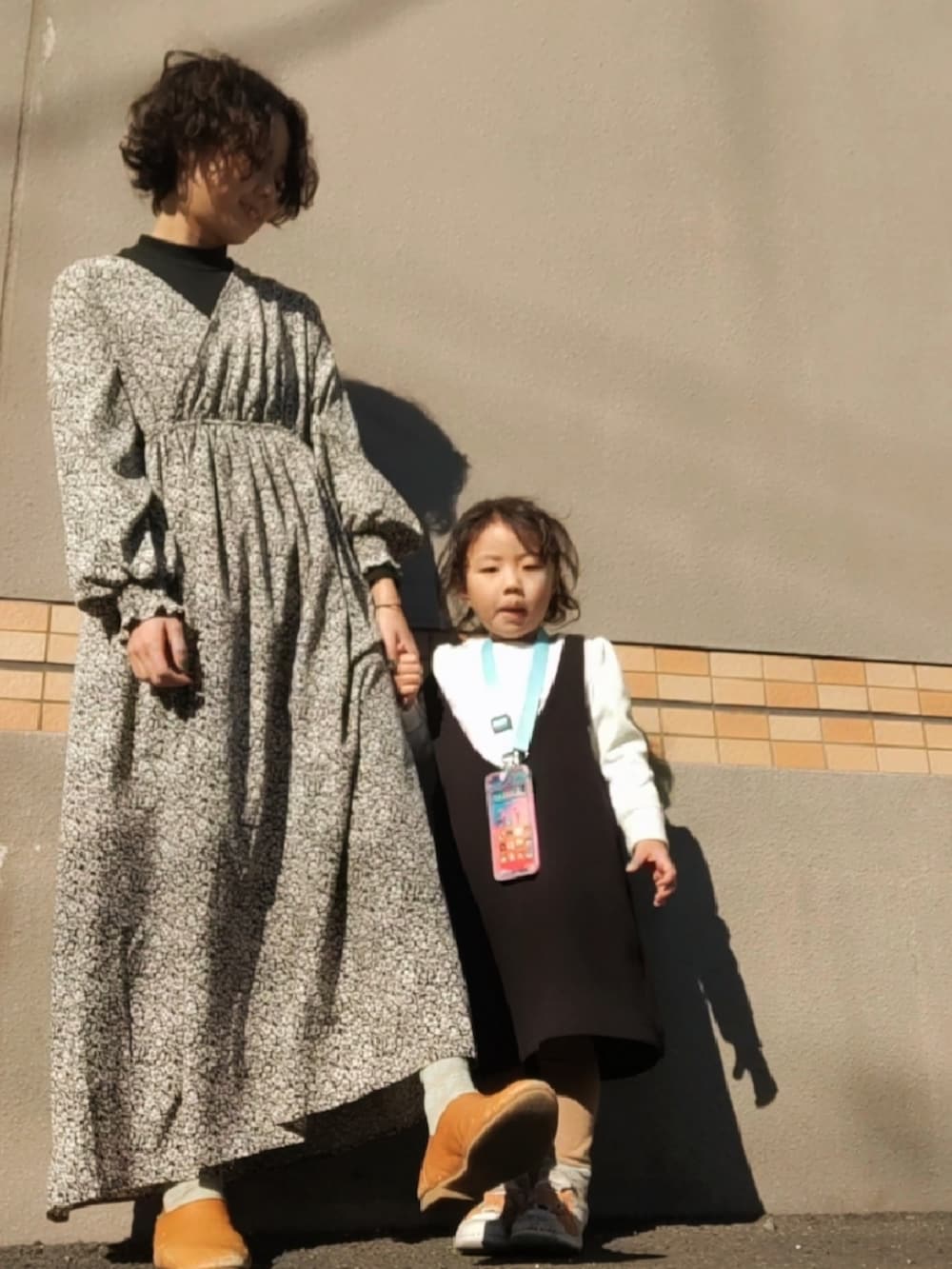 ホワイト系のスリッポン、ブラウン系のスリッポン、ブラック系のワンピースを着用したレディースの冬コーディネートの2枚目の写真