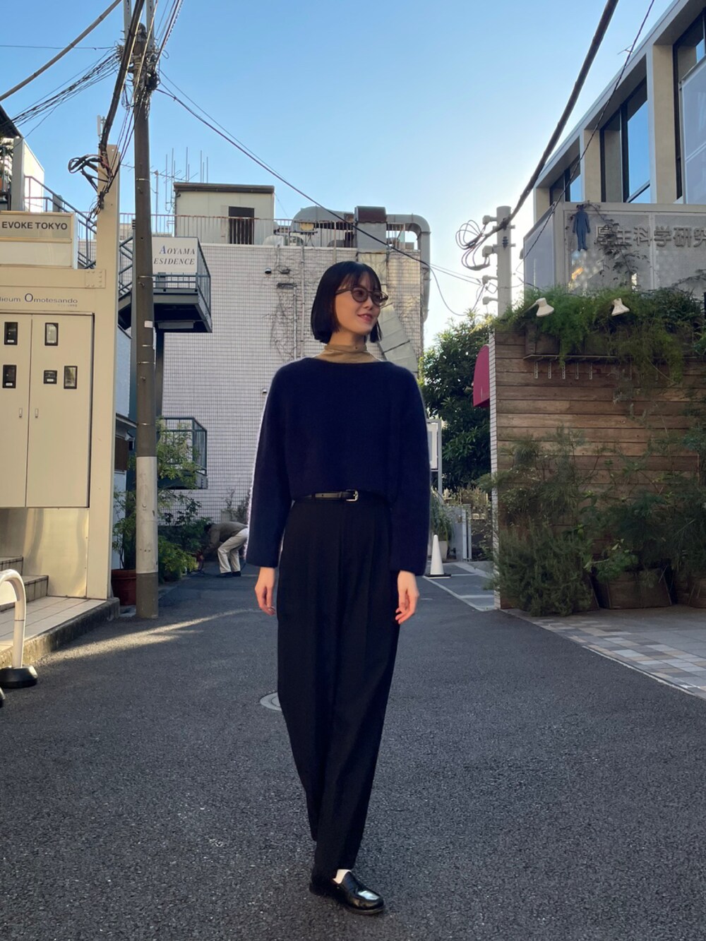 グリーン系のサングラスを着用したレディースの秋コーディネートの2枚目の写真