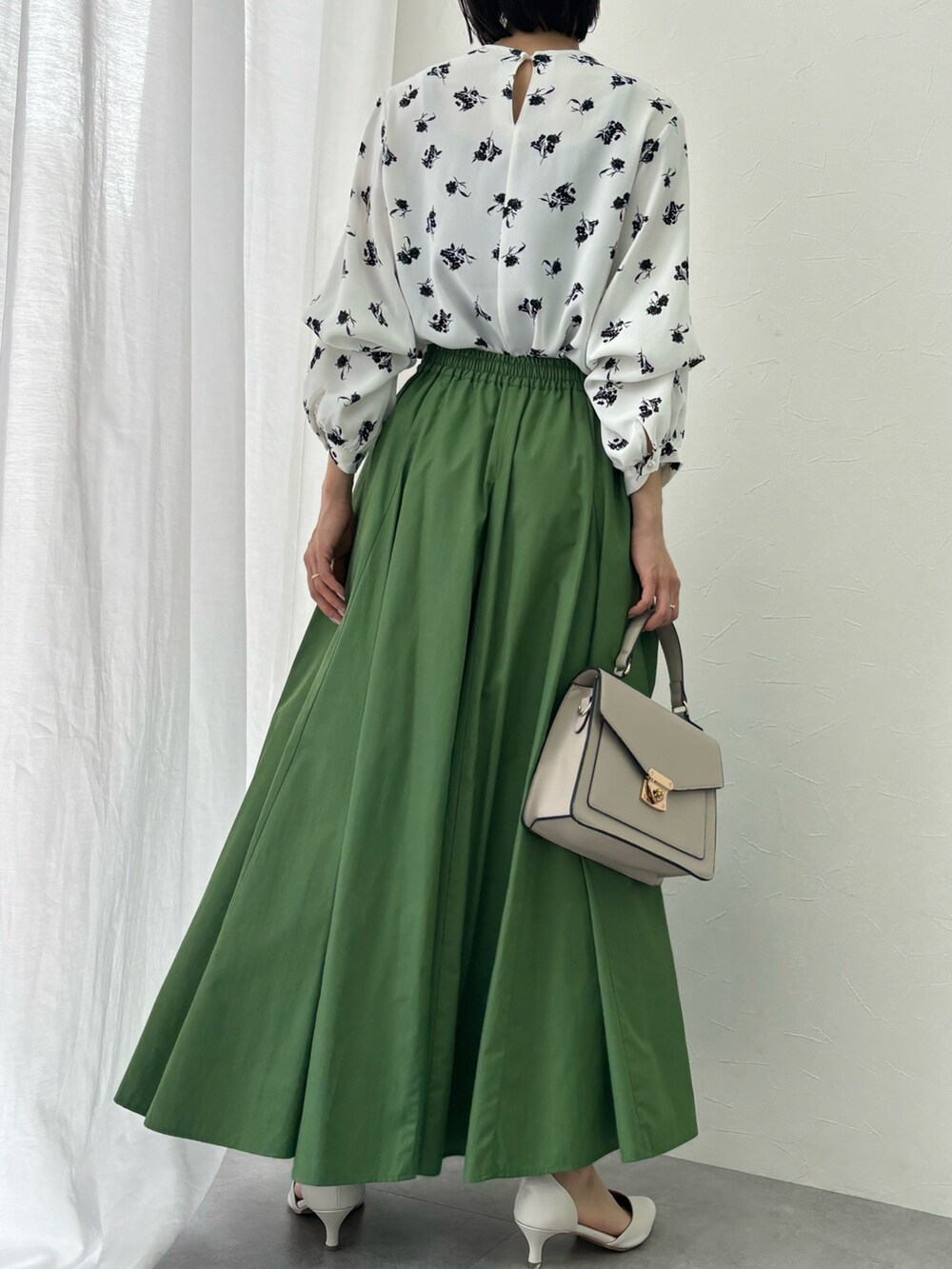 グリーン系のスカート、ホワイト系のシャツ/ブラウスを着用したレディースの春コーディネートの2枚目の写真