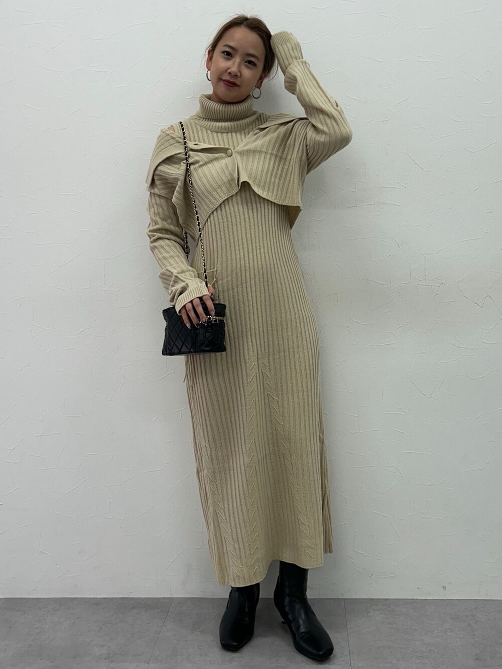 ベージュ系のワンピース、ブラック系のブーツを着用したレディースの冬コーディネートの4枚目の写真