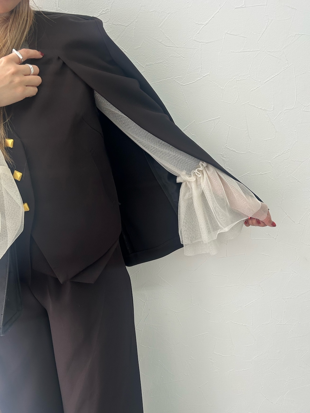 ブラック系のスーツセット、ホワイト系のシャツ/ブラウスを着用したレディースの冬コーディネートの4枚目の写真