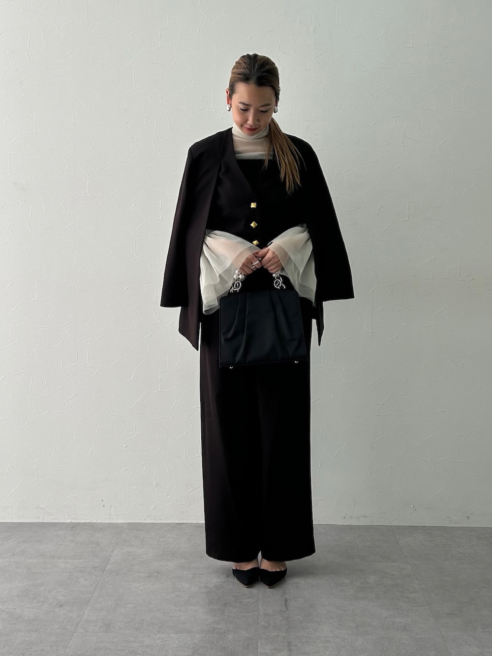 ブラック系のスーツセット、ホワイト系のシャツ/ブラウスを着用したレディースの冬コーディネートの3枚目の写真