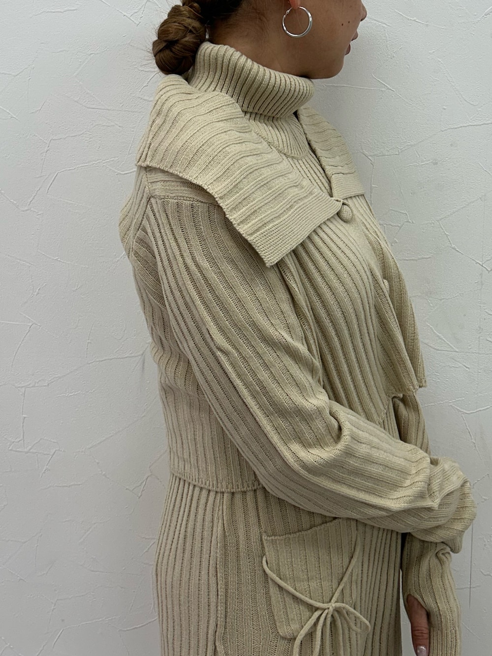 ベージュ系のワンピース、ブラック系のブーツを着用したレディースの冬コーディネートの6枚目の写真