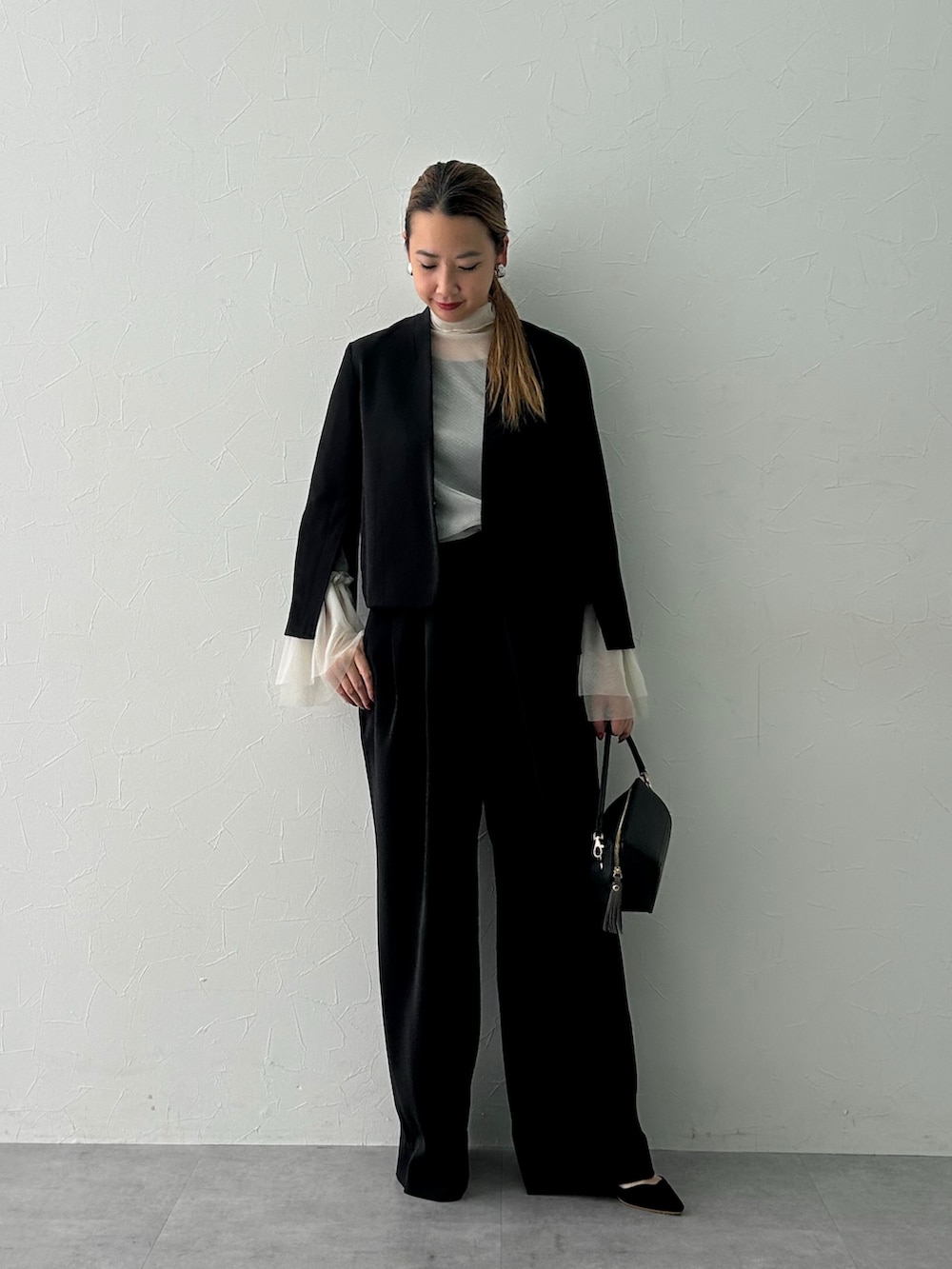 ブラック系のスーツセット、ホワイト系のシャツ/ブラウスを着用したレディースの冬コーディネートの4枚目の写真