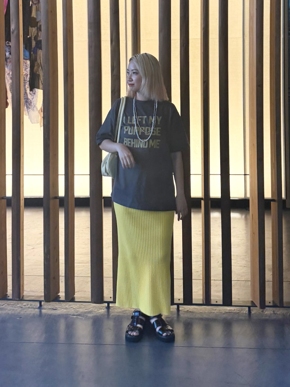 グレー系のTシャツ/カットソー、イエロー系のスカートを着用したレディースの夏コーディネートの4枚目の写真