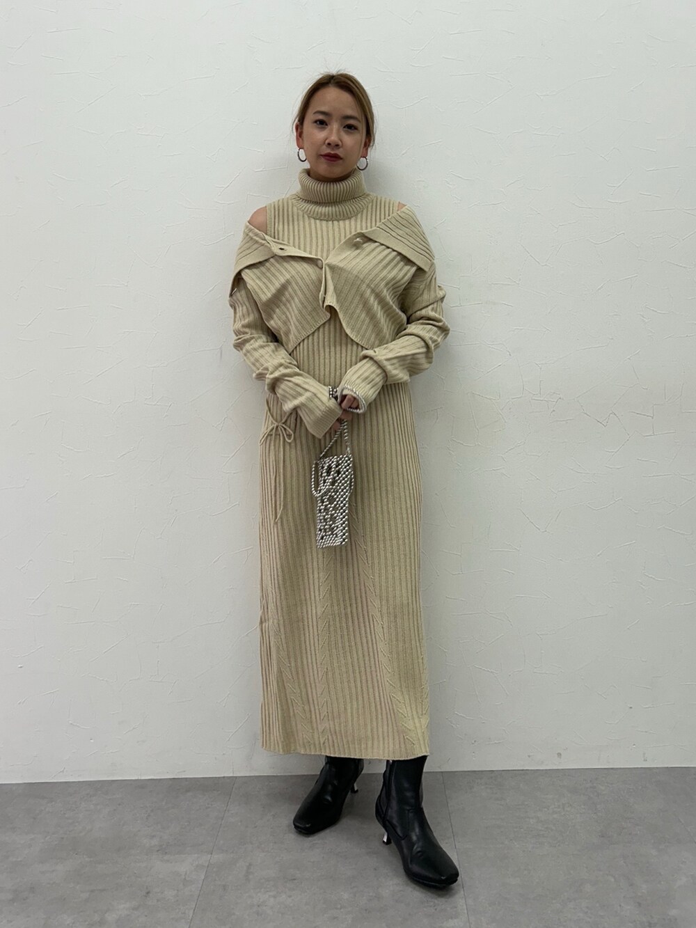 ベージュ系のワンピース、ブラック系のブーツを着用したレディースの冬コーディネートの3枚目の写真