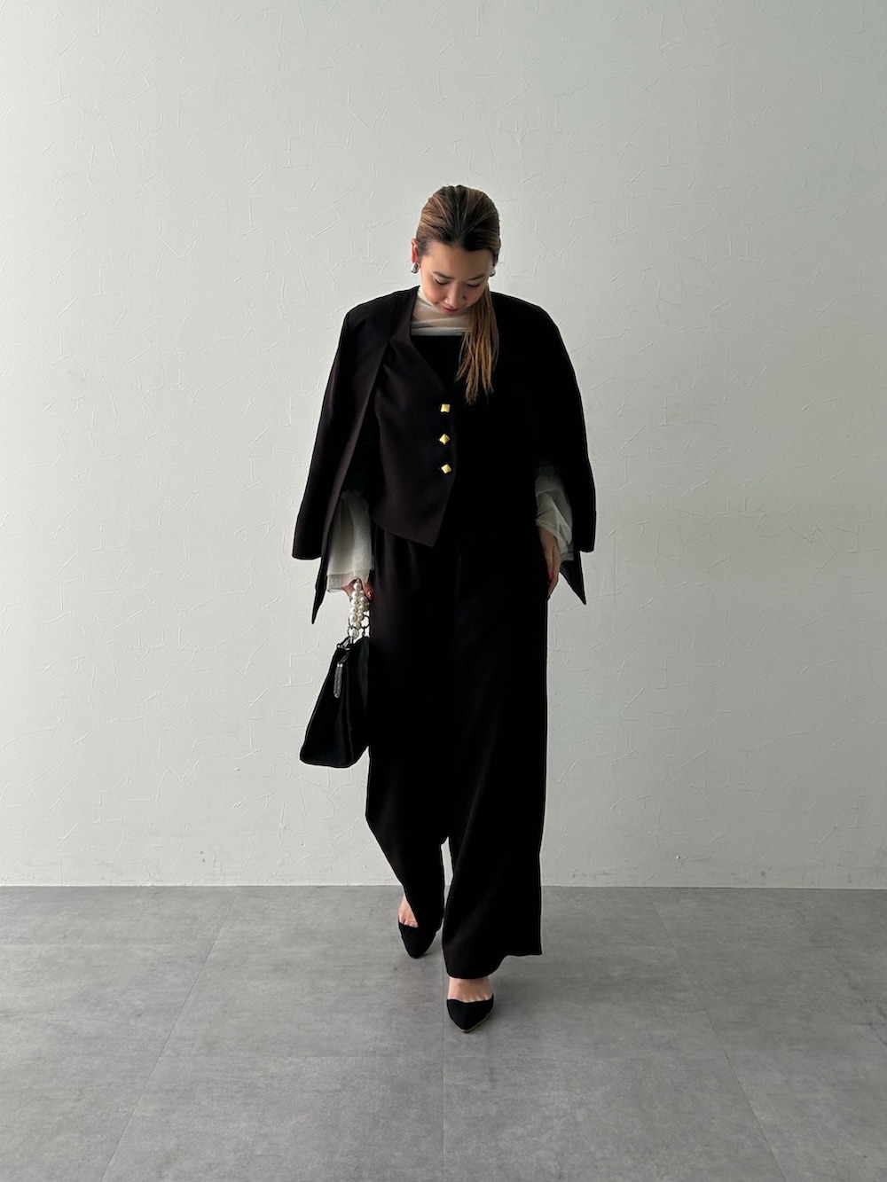 ブラック系のスーツセット、ホワイト系のシャツ/ブラウスを着用したレディースの冬コーディネートの2枚目の写真