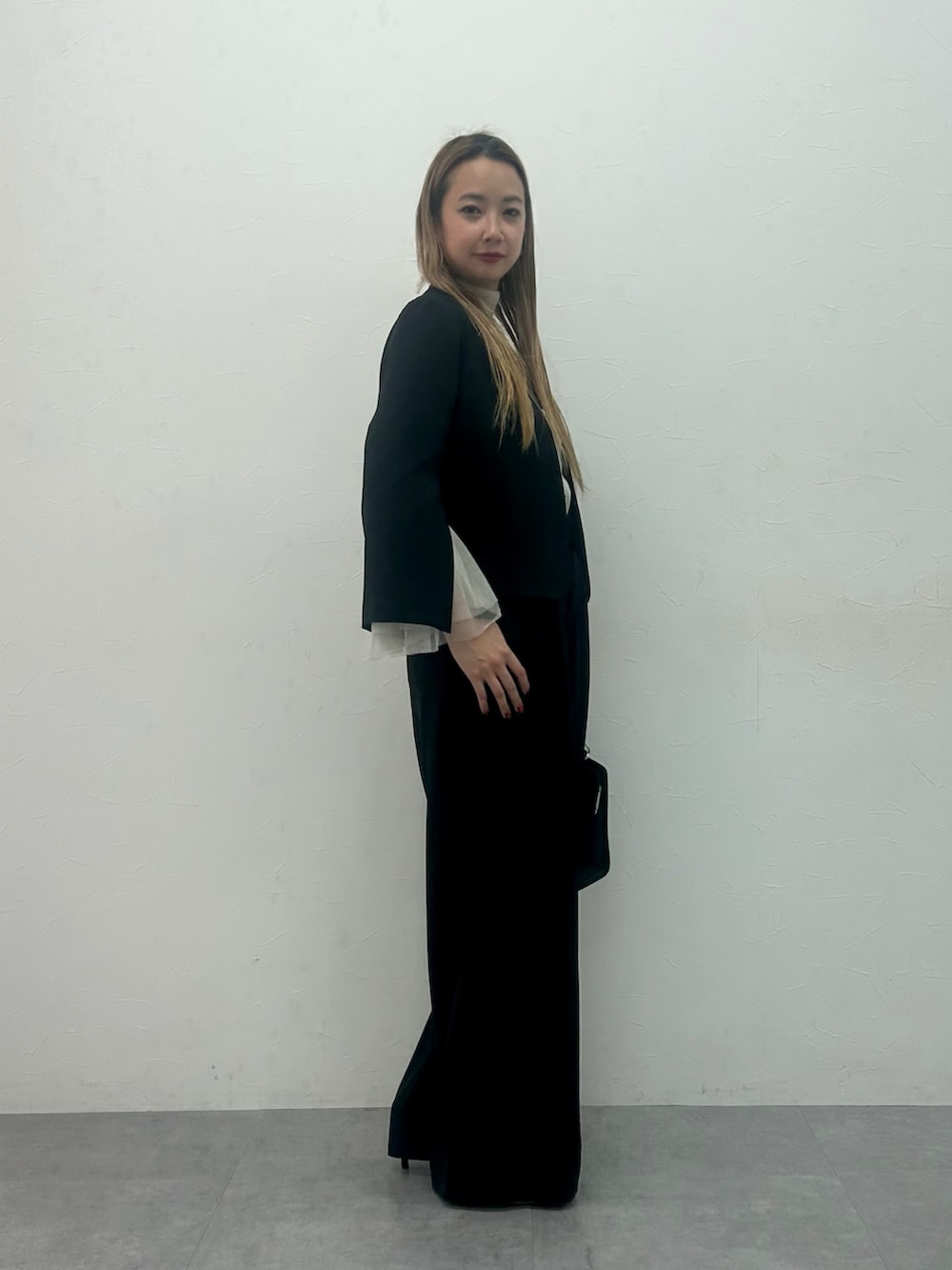 ブラック系のスーツセット、ホワイト系のシャツ/ブラウスを着用したレディースの冬コーディネートの2枚目の写真