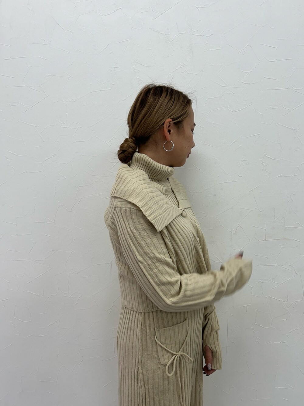 ベージュ系のワンピース、ブラック系のブーツを着用したレディースの冬コーディネートの7枚目の写真