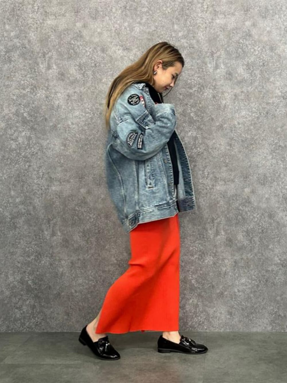 ブルー系のデニムジャケット、オレンジ系のスカートを着用したレディースの春コーディネートの3枚目の写真