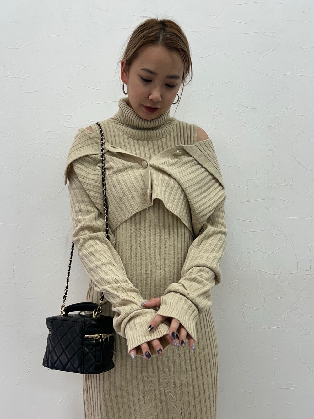 ベージュ系のワンピース、ブラック系のブーツを着用したレディースの冬コーディネートの5枚目の写真