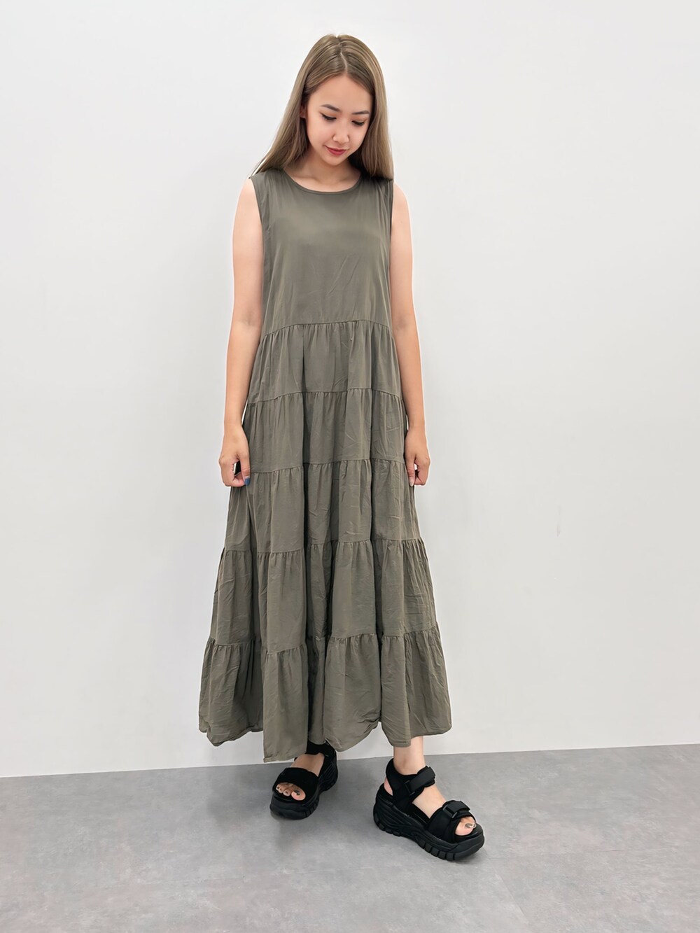 ブラウン系のワンピース、ホワイト系のニット/セーター、ブラック系のサンダルを着用したレディースの夏コーディネートの2枚目の写真