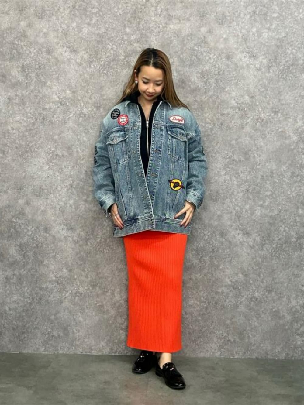 ブルー系のデニムジャケット、オレンジ系のスカートを着用したレディースの春コーディネートの2枚目の写真