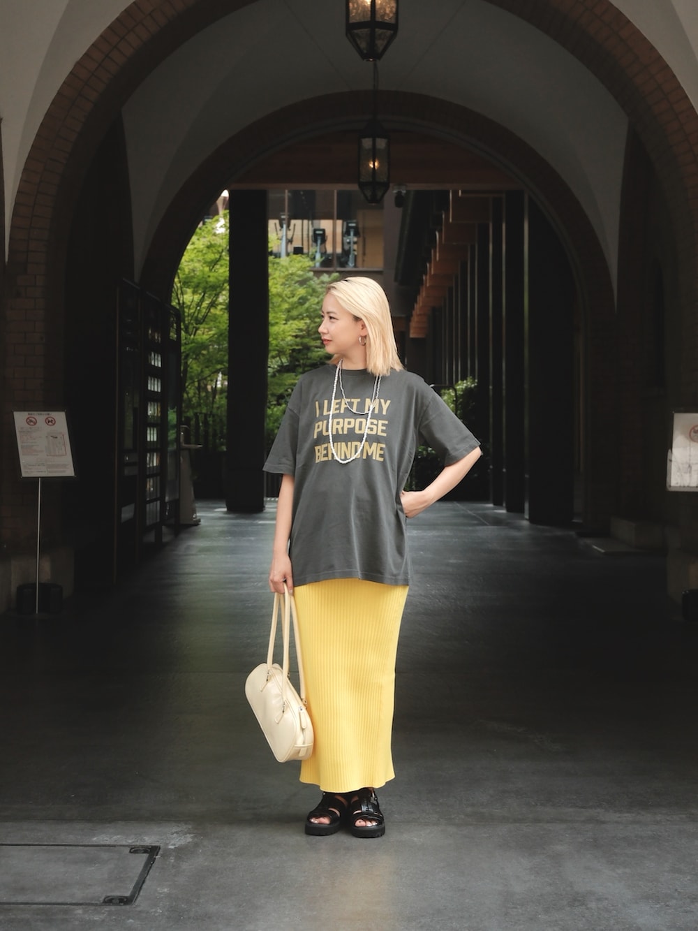 グレー系のTシャツ/カットソー、イエロー系のスカートを着用したレディースの夏コーディネートの3枚目の写真