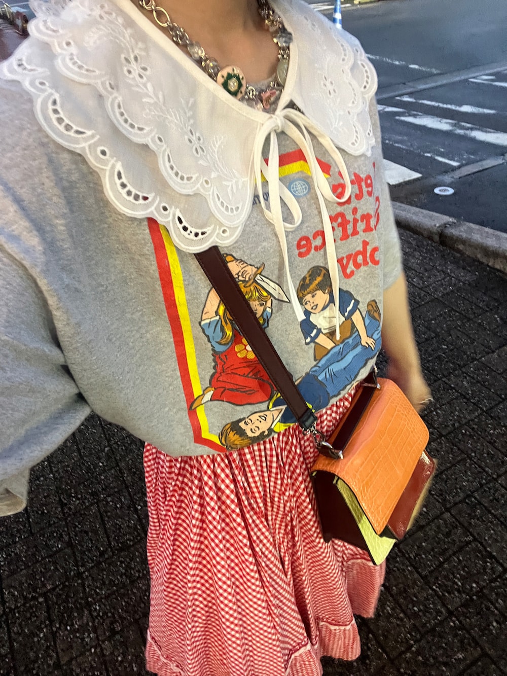 オレンジ系のショルダーバッグを着用したレディースの夏コーディネートの2枚目の写真