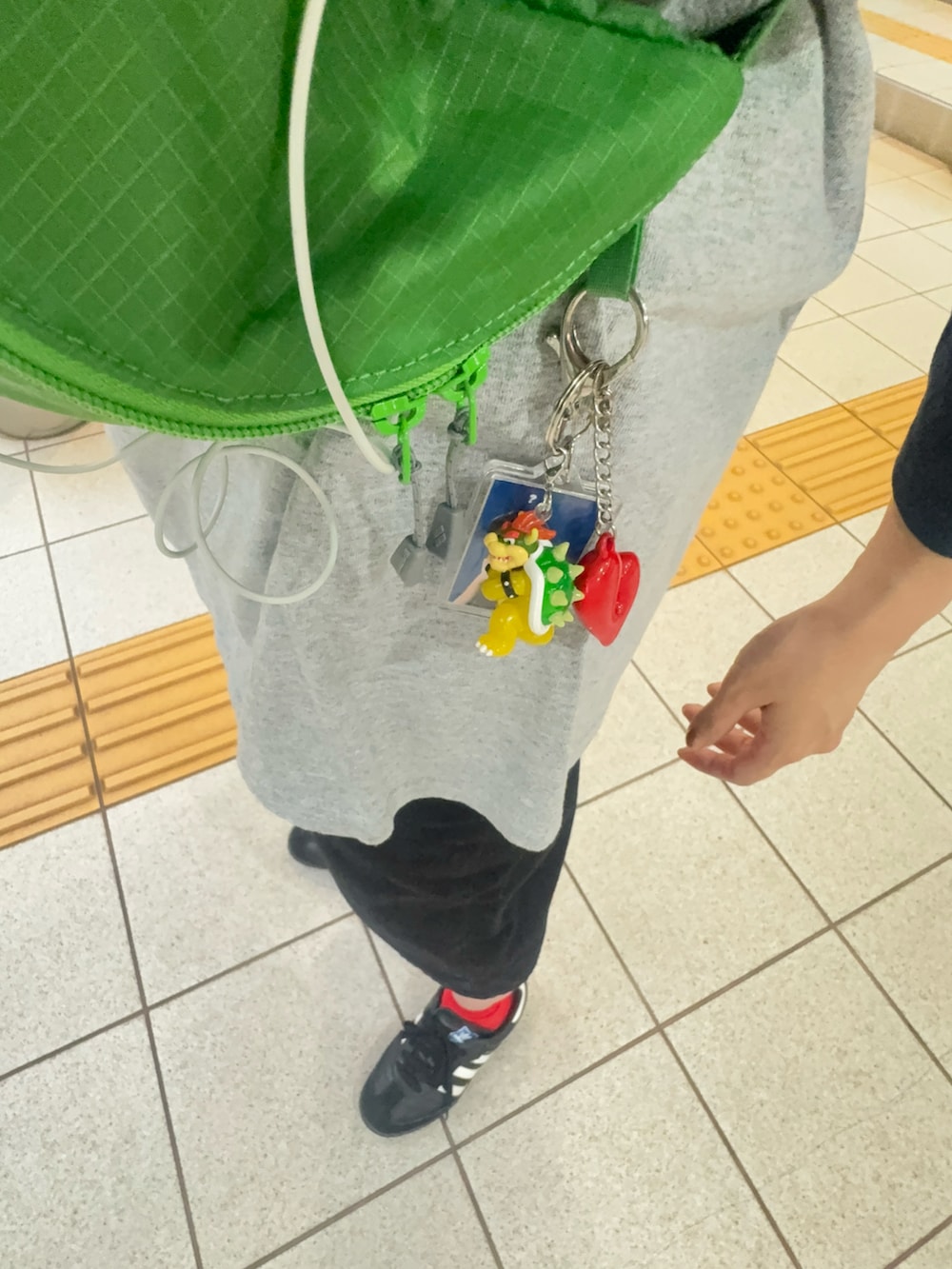 ブラック系のパンツ、グリーン系のボディバッグ/ウエストポーチ、ブラック系のスニーカーを着用したレディースの春コーディネートの3枚目の写真