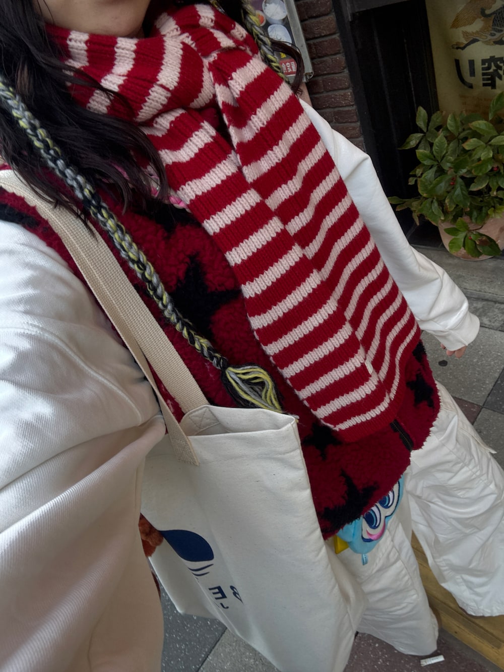 ホワイト系のパンツ、ピンク系のスニーカー、ホワイト系のトートバッグを着用したレディースの冬コーディネートの3枚目の写真