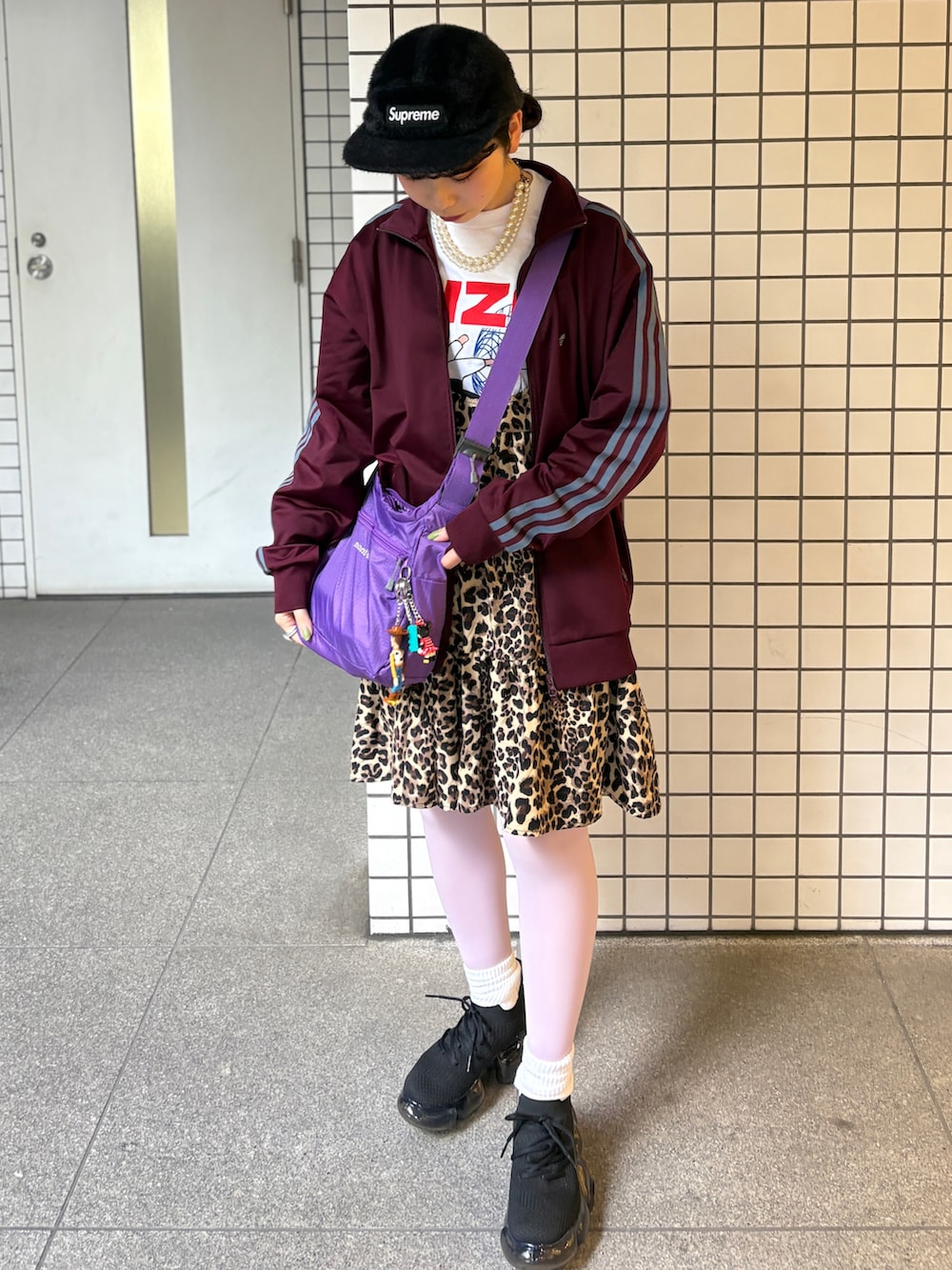 ブラック系のスニーカー、パープル系のショルダーバッグ、パープル系のジャケット/アウターを着用したレディースの春コーディネートの3枚目の写真