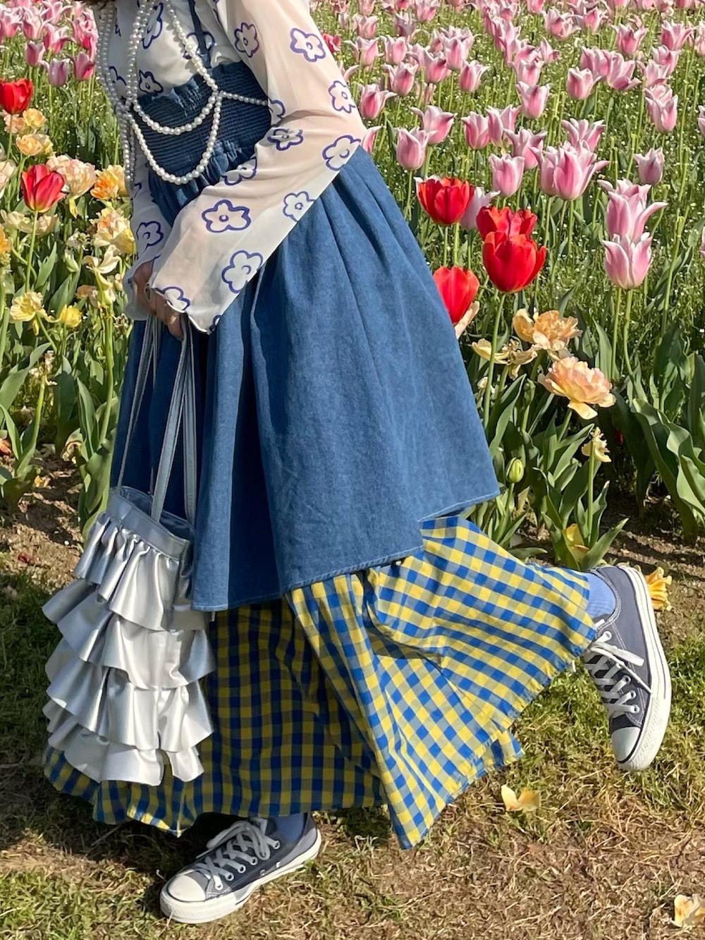 シルバー系のバッグ、イエロー系のスカート、ブルー系のワンピース/ドレスを着用したレディースの春コーディネートの2枚目の写真