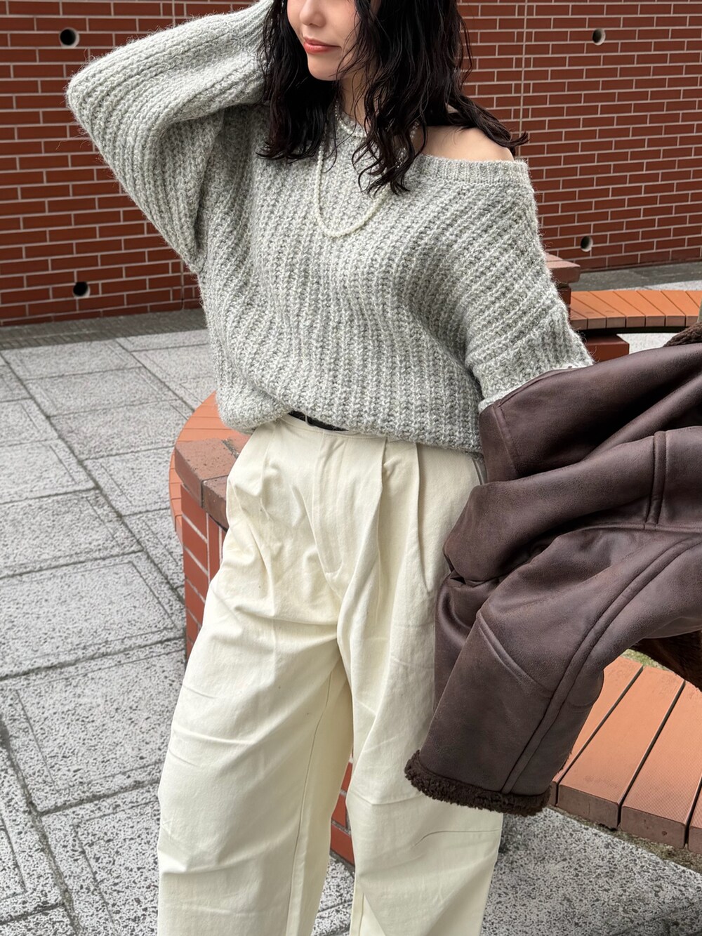 ホワイト系のチノパンツ、グレー系のニット/セーター、ブラック系のベルトを着用したレディースの冬コーディネートの5枚目の写真